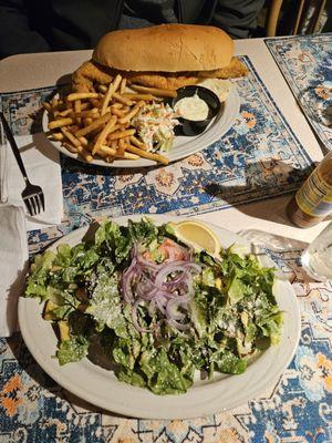 Cesar salad and fried haddock sandwich with fries and coleslaw