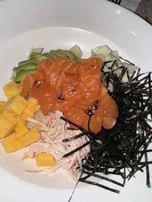 Poke bowl with salmon, tamago, cucumber, avocado, krab salad, and crunchy nori