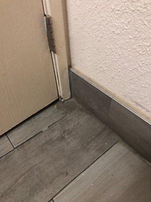 Bathroom floor behind door.