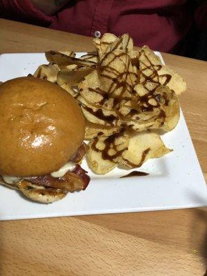 Chicken sandwich and chips with a balsamic vinaigrette drizzle.