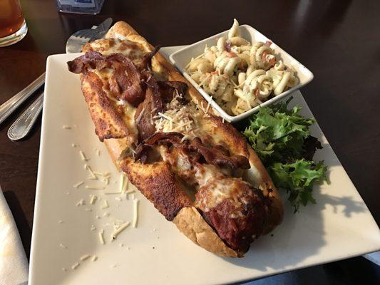 Meatball sub on Asiago cheese covered roll with beacon.