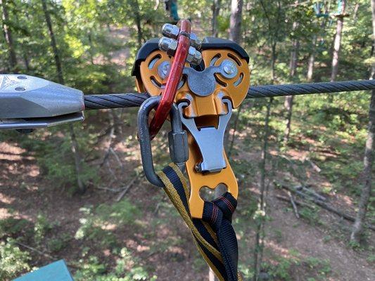 Orange zipline pulley and red hook