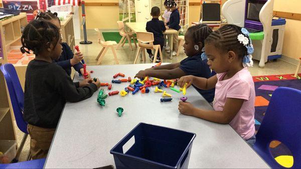 Children engaged in "hands-on learning stations"  and "manipulative centers."  Learning through PLAY.