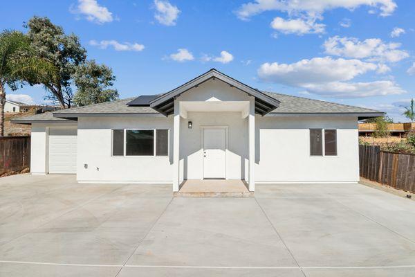 Front view of the newly completed 2-bedroom home, featuring clean lines, modern design, and solar power for sustainable living.