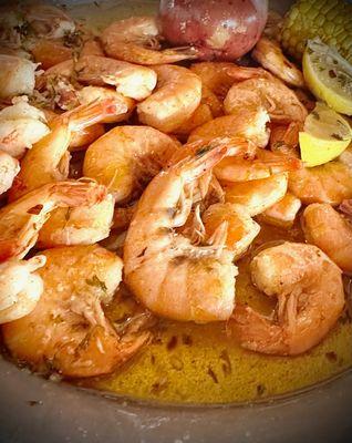 Spicy garlic butter shrimp includes, lemon wedges, a potato and corn on the cob!  My favorite item to order!