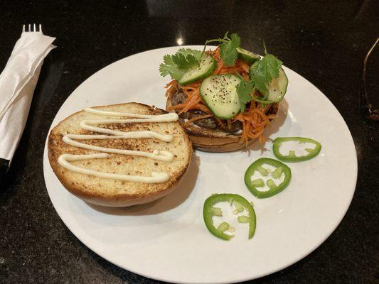 Open faced Spicy Vietnamese Burger plating with jalapeño on the side