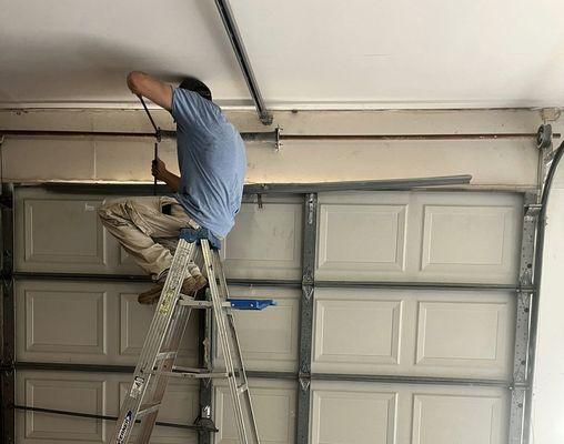 Our professional technician works on final repairs before completing the installation of a new garage door