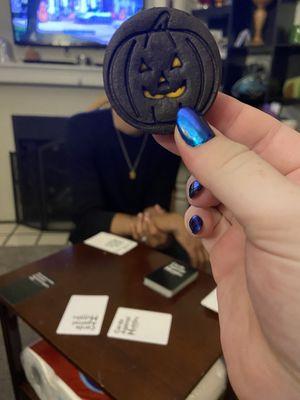 Me holding a pumpkin cookie showing my nail design