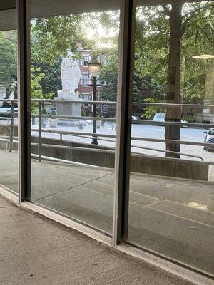 A view of the George Washington statue as viewed through the mirrored windows at the side of the building.