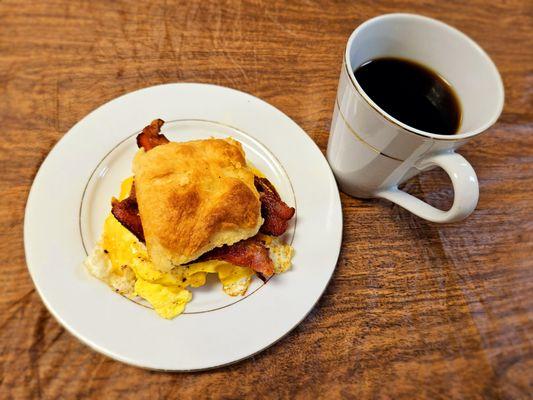 Bacon, egg and cheese biscuit breakfast sandwich with coffee