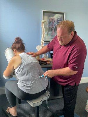 Dr. James T. Sheneman treating a patient with advanced technology, The PROAdjuster, comfortable & precise Chiropractic Treatment