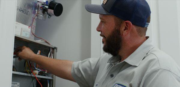 Ebens Air Conditioning & Plumbing Technician working in a customers home.