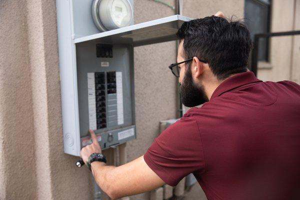 Matt Bano inspecting the electrical panel during a home inspection.