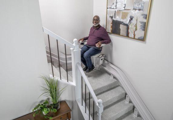 man riding custom curved stairlift from Lifeway Mobility in Akron, OH