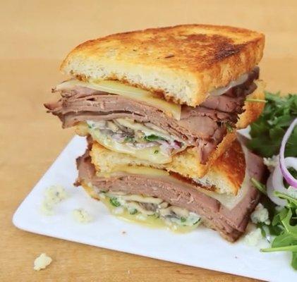 The mountain: roast beef A1 steak sauce arugula provolone cheese sautéed mushrooms and onions on sourdough bread