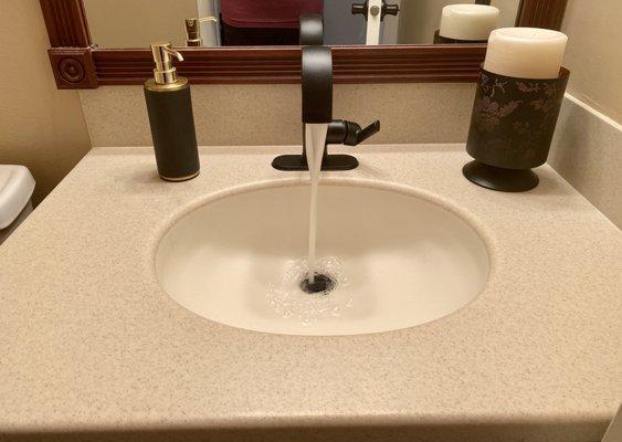 This Moen black matte faucet is beautiful and paired with gold accents makes this powder room feel luxurious.