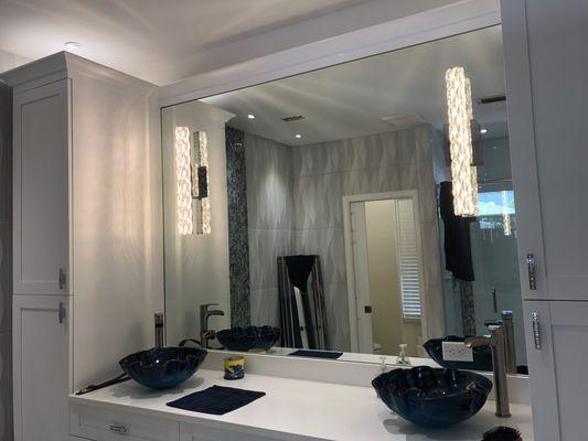 Lighting sconces installed on mirror panel