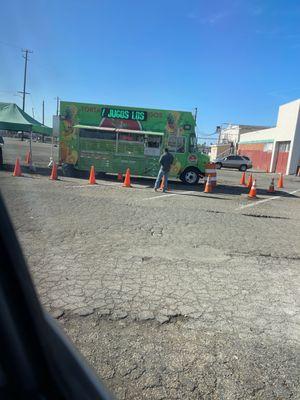 The taco truck is located in the parking lot of food barn