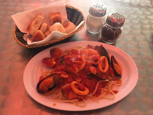 Seafood pasta, zuppa di pesce, hot pepper shaker, Parmesan cheese shaker, homemade Italian bread rolls