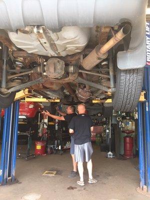 The mechanic showing my hubby the ugly underbelly of my car.