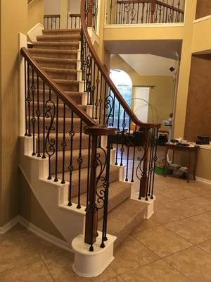 Staircase remodeled with wrought iron balusters and stain changed to a darker tone.