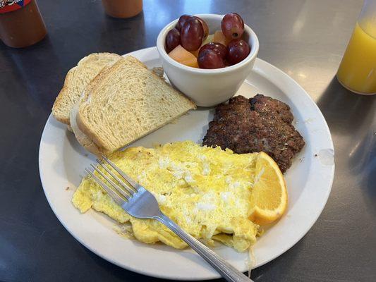 Eggs, house made sausage, fruit, and sourdough toast.