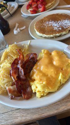 Bacon, hashbrowns, eggs with American cheese and pancakes.