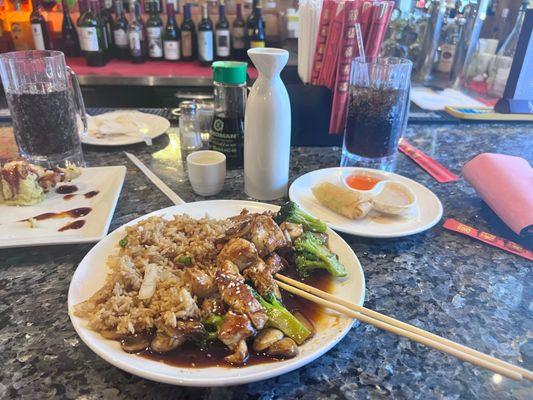 Chicken teriyaki hibachi with Pepsi and hot sake and a spring tool and steamed dumplings