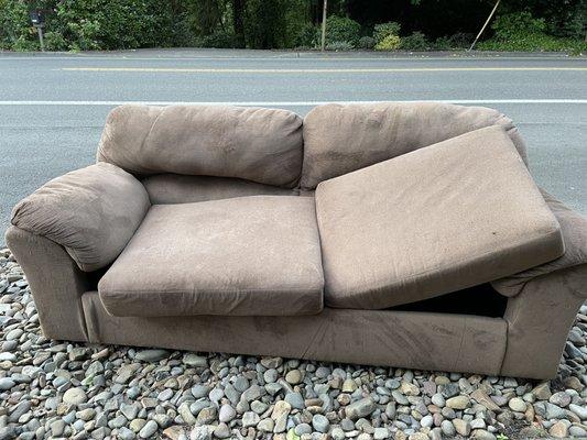 Old ugly loveseat abandoned in front of our neighborhood.