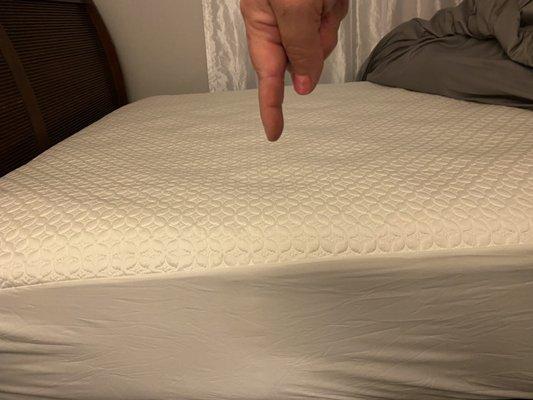 Pointing to the area that sinks in when laying on the bed