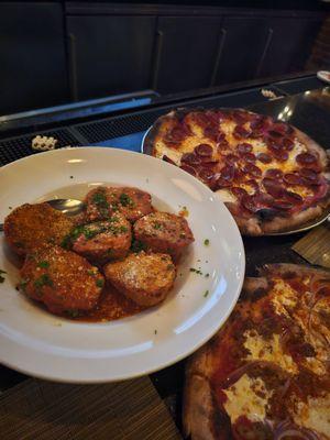 Delicious meatballs and a pepperoni and a sausage pizza