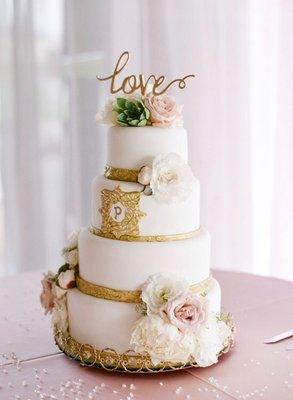 Four tiered fondant wedding cake with gold accents.