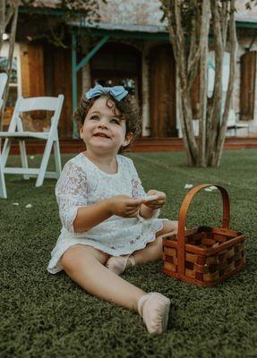 Flower girl cleaning up her petals in the garden after a ceremony