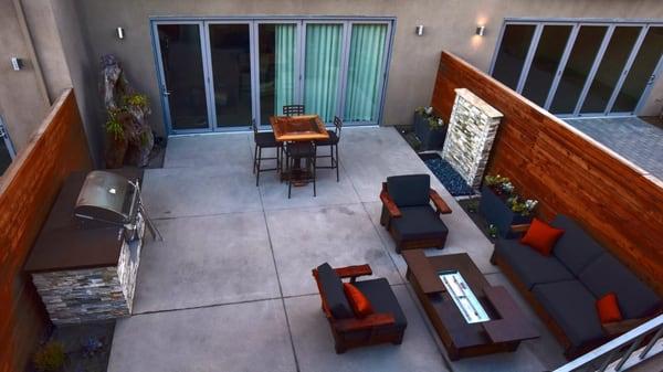 View down to the courtyard.  Concrete is so smooth.  Water feature to the top right.  The chairs with their cushions.