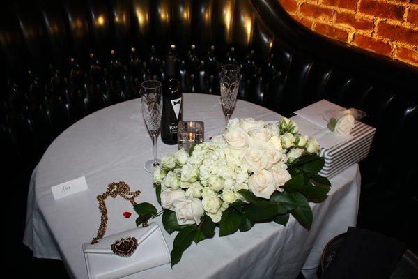 The sweetheart table perfectly adorned with white roses and hydrangeas.