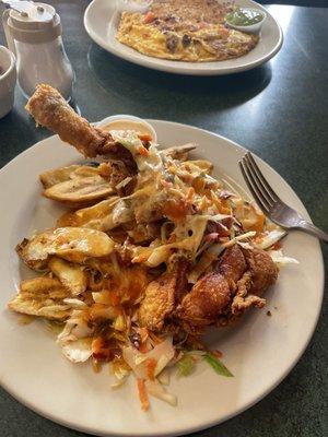 Chicken w/ fried green bananas and slaw. In the background. chorizo omelette and hash browns.