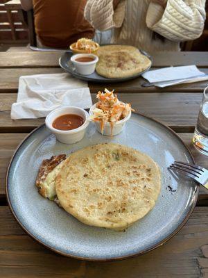 Front: cheese and jalapeño pupusa  Back: carnita pupusa