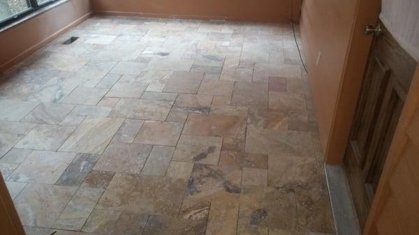 Installed a beautiful travertine tile floor in a versales pattern on a 150 sf sunroom floor .