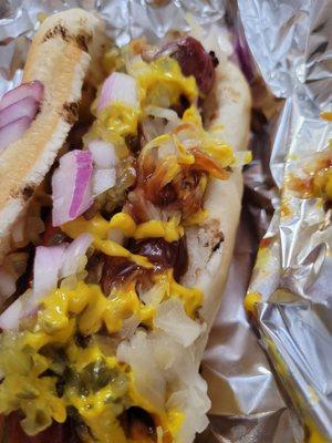 Hot dog from the grill with red onion, sauerkraut, mustard and BBQ sauce. It's a little messy because it was wrapped in foil, but so good!