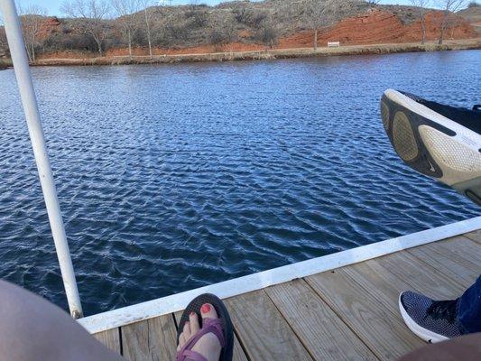 Sitting on the dock, enjoying the sunny weather and cool breeze.