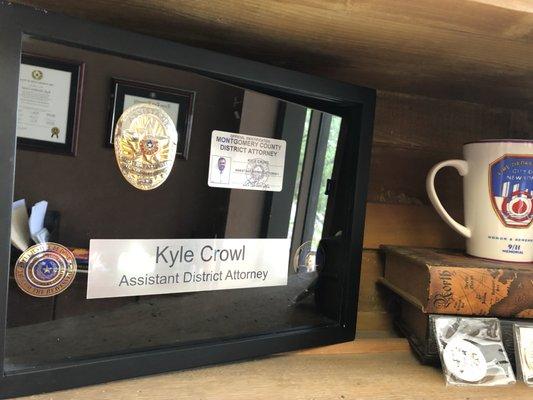 Kyle's badge, ID and nameplate from his time at the District Attorney's Office .