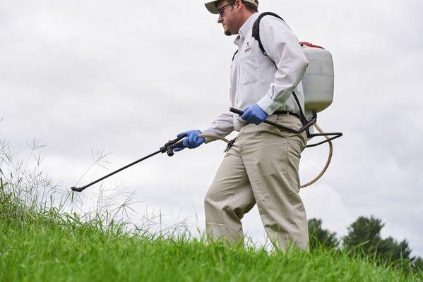 Service professional treating for mosquitos, fleas, and ticks