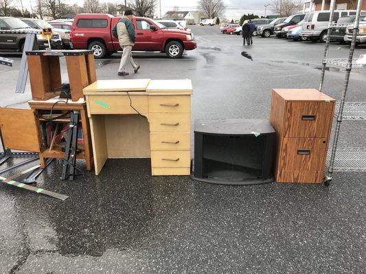 Sewing machine in wooden cabinet & tv stand sitting in rain outside prior to being auctioned