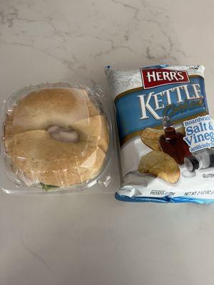 Turkey sandwich on plain bagel and a bag of salt and vinegar chips