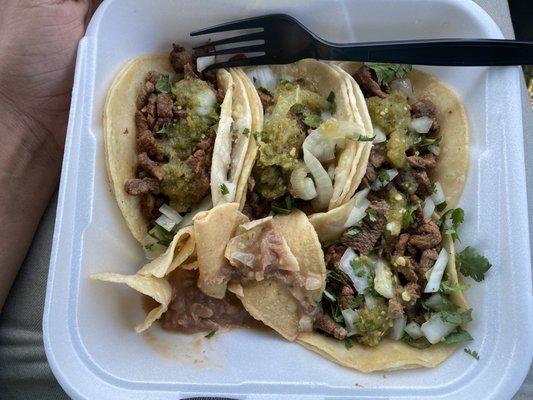 Carne Asada Tacos with chile verde. Flavorful beans and chips on the side.