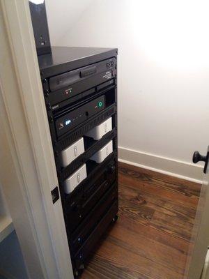 Equipment rack neatly installed under stairs.