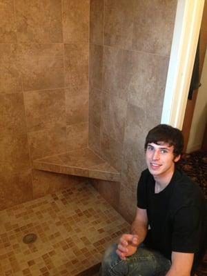 Luke a master tile installer finishing cleanup of grout on new shower he built