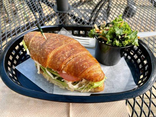 Turkey sandwich on croissant with signature kale salad.