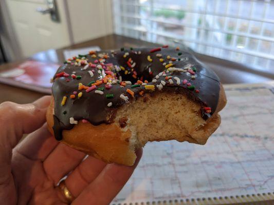 Raised donut with chocolate icing and sprinkles