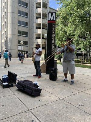 Musicians busk at Shady Grove Metro Station.